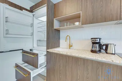 a kitchen with wooden cabinets and a refrigerator at Best Stay - City Views Gym & Pool in Miami