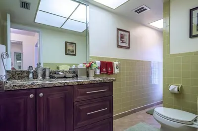 a bathroom with a sink and a toilet and a mirror at Oasis1080 Resort in Plantation