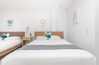 two beds in a bedroom with white walls at North Bay in Miami Beach