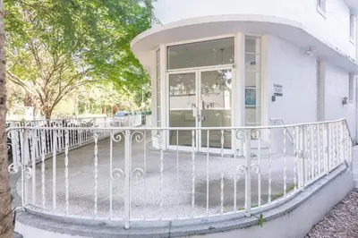 a white house with a balcony with a glass door at Convention Center in Miami Beach