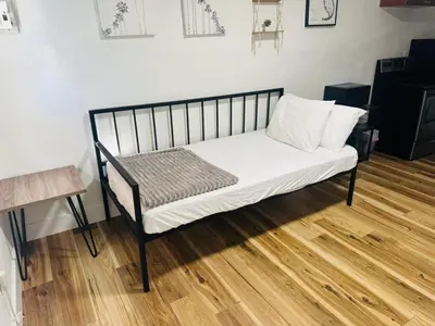 a black and white bed in a room with a wooden floor at Cozy place Near Design District - 1 in Miami