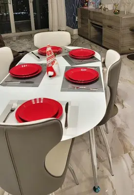 a white dining table with red plates on it at Luxury Apt with Ocean View in Hallandale in Hallandale Beach