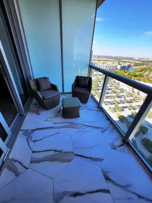 a room with two chairs in a room with windows at The Royal Studio of Beachwalk in Hallandale Beach