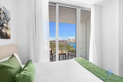 a bedroom with a bed and a view of the ocean at Unique 2BR Apartment Gym & Pool in Hallandale Beach