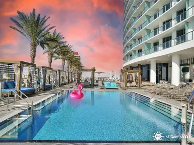 a large swimming pool with a pink inflatable raft at Ocean Views - Balcony & Resort Pool Paradise in Hollywood