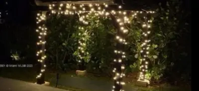 a group of white lights in a garden at night at The Miami Enchanted Lake House in Ojus
