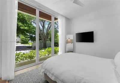 a white bedroom with a bed and a large window at Villa Tranquil Luxe Modern Oasis with Private Pool in Miami Beach in Miami Beach