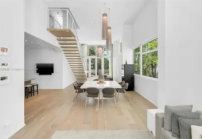 a dining room with a table and a staircase at Villa Tranquil Luxe Modern Oasis with Private Pool in Miami Beach in Miami Beach