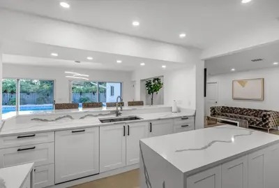 a kitchen with white cabinets and a large white island at Opulent Home with Sauna & Pool in Hollywood