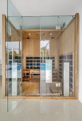 a glass wall in a room with a table at Opulent Home with Sauna & Pool in Hollywood