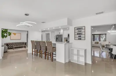 a kitchen and living room with a table and chairs at Opulent Home with Sauna & Pool in Hollywood