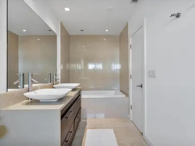 a bathroom with two sinks and a bath tub at luxury house by the water in Eastern Shores