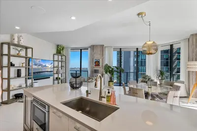 a kitchen and living room with a view of the ocean at POSH Ocean View Penthouse - Heated Pool, Gym, Office! 10mins Beach in Miami