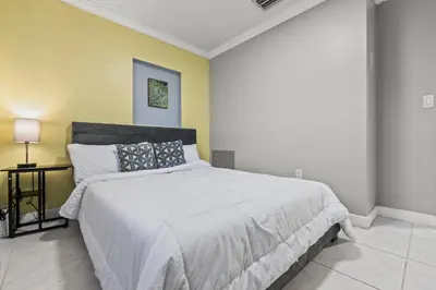 a bedroom with a large bed and a yellow wall at Fort Lauderdale Retreat Near Beach & Airport in Fort Lauderdale