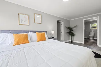 a bedroom with a large white bed with orange pillows at Fort Lauderdale Retreat Near Beach & Airport in Fort Lauderdale