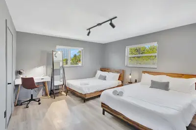 a bedroom with two beds and a desk in it at Newly Renovated 1BR Condo Near South Beach in Miami Beach