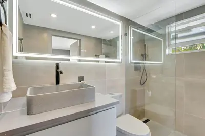a bathroom with a sink and a toilet and a mirror at Newly Renovated 1BR Condo Near South Beach in Miami Beach
