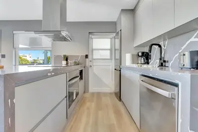 a kitchen with white counters and stainless steel appliances at Newly Renovated 1BR Condo Near South Beach in Miami Beach