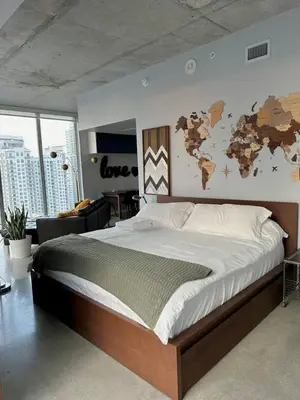 a bedroom with a large bed with a world map on the wall at Luxury Loft 270 views, Rooftop Pool, Parking in Miami