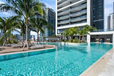 a large swimming pool with palm trees and a building at NEW Suite Downtown Miami - Amazing view 27th floor in Miami