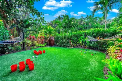 a yard with red buckets and balls on the grass at Beach Estate Las Olas Beach Best Location in Fort Lauderdale