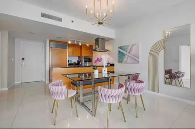a kitchen with pink chairs and a dining table at Icon Brickell Amazing Ocean View in Miami