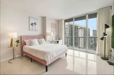 a bedroom with a bed and a large window at Icon Brickell Amazing Ocean View in Miami