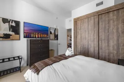 a bedroom with a large bed and a dresser at On The 49th Floor! Condo on Highest & Free Parking in Miami