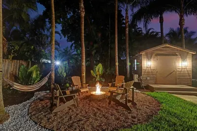 a fire pit in a yard with chairs and a shed at The Grand Luxe 8BR Villa w POOL and basketball in Pembroke Pines