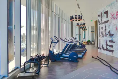 a gym with a row of blue treadmills at Condo w Breathtaking Views & Top Amenities in Hollywood