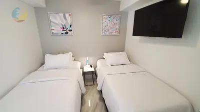 a room with three beds and a flat screen tv at Alexander 1001 in Miami Beach