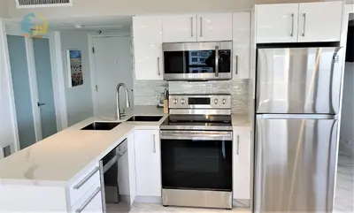 a kitchen with white cabinets and a stainless steel refrigerator at Alexander 1001 in Miami Beach