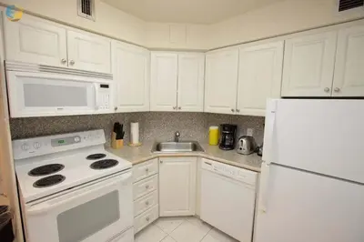 a kitchen with white cabinets and a white refrigerator at Alexander 1010 in Miami Beach