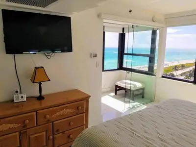 a bedroom with a television and a dresser with a bed at Alexander 1101 in Miami Beach