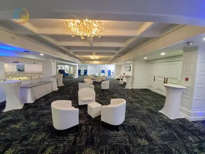 a large room with white chairs and tables and a chandelier at Alexander 1102 in Miami Beach
