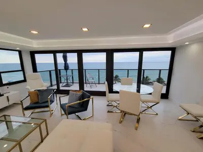 a living room with a table and chairs and the ocean at Alexander 1102 in Miami Beach