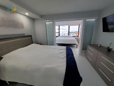 a bedroom with a white bed and a television at Alexander 1104 in Miami Beach