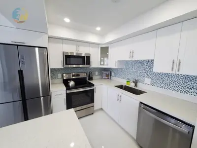 a kitchen with white cabinets and stainless steel appliances at Alexander 1104 in Miami Beach