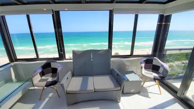 a room with chairs and the ocean in the background at Alexander 1401 in Miami Beach