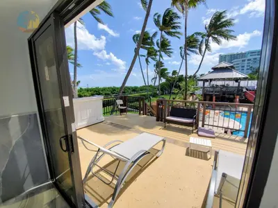 a balcony with a view of a pool and palm trees at Alexander 1401 in Miami Beach