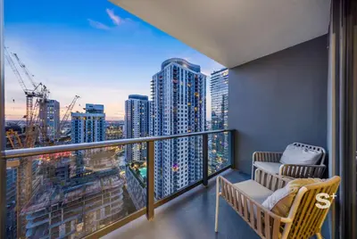 a balcony with two chairs and a view of a city at Stylish Downtown 1-BD Condo in Miami