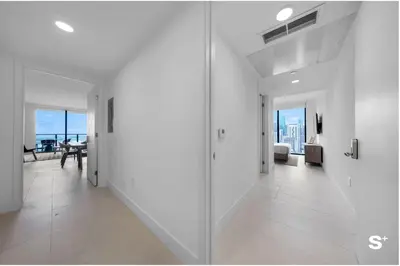 a white hallway with a dining room and a living room at Upscale 3-BD Condo in Downtown Miami in Miami