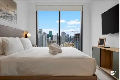 a bedroom with a large white bed with a large window at Upscale 3-BD Condo in Downtown Miami in Miami