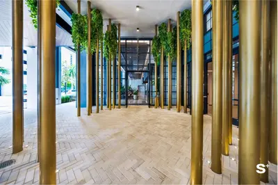 a hallway with gold columns and plants in a building at Luxury Studio in DTW Miami with City Views in Miami