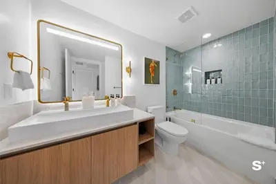 a bathroom with a sink and a toilet and a mirror at Luxury Studio in DTW Miami with City Views in Miami
