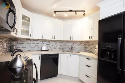 a kitchen with white cabinets and a black refrigerator at Alexander 1419 in Miami Beach