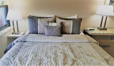 a bedroom with a bed with pillows and two lamps at Alexander 1618 in Miami Beach