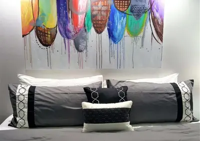 a bed with two pillows and a painting of balloons at Alexander 518 in Miami Beach