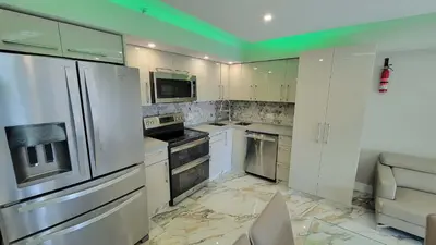 a kitchen with stainless steel appliances and white cabinets at Alexander 521 in Miami Beach