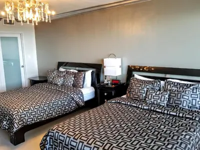 a bedroom with two beds and a chandelier at Alexander 604 in Miami Beach